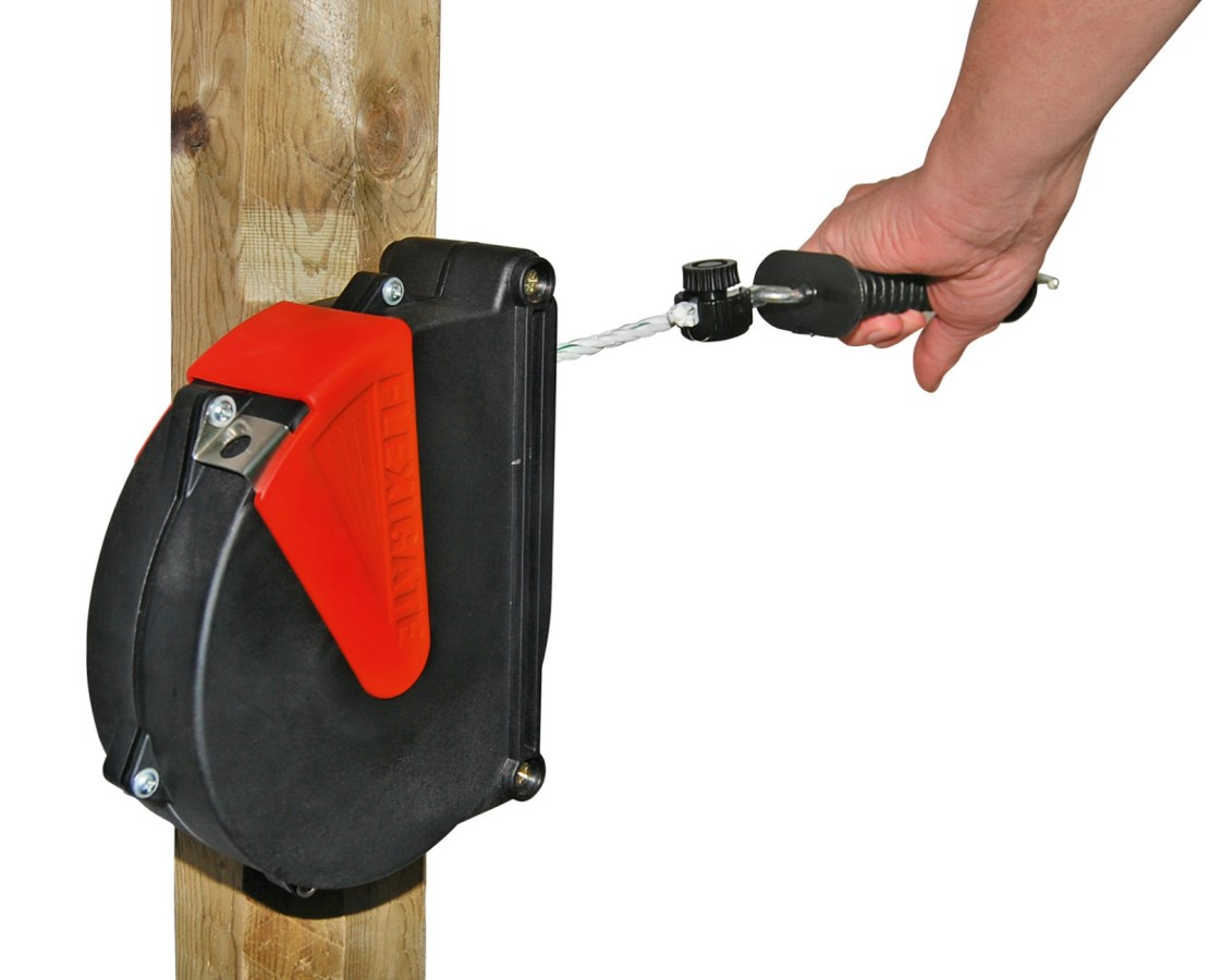 Hand verbindet elektrisches Band mit Zaunanschlusskabel an Holzpfosten