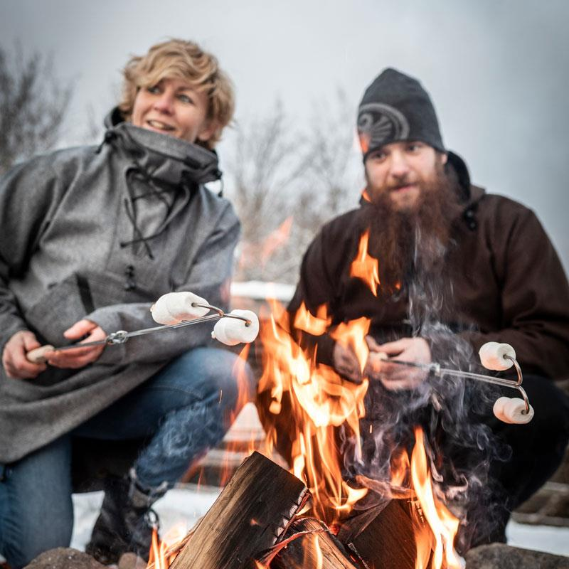 Zwei Personen rösten Marshmallows über einem Lagerfeuer mit Petromax Spießen