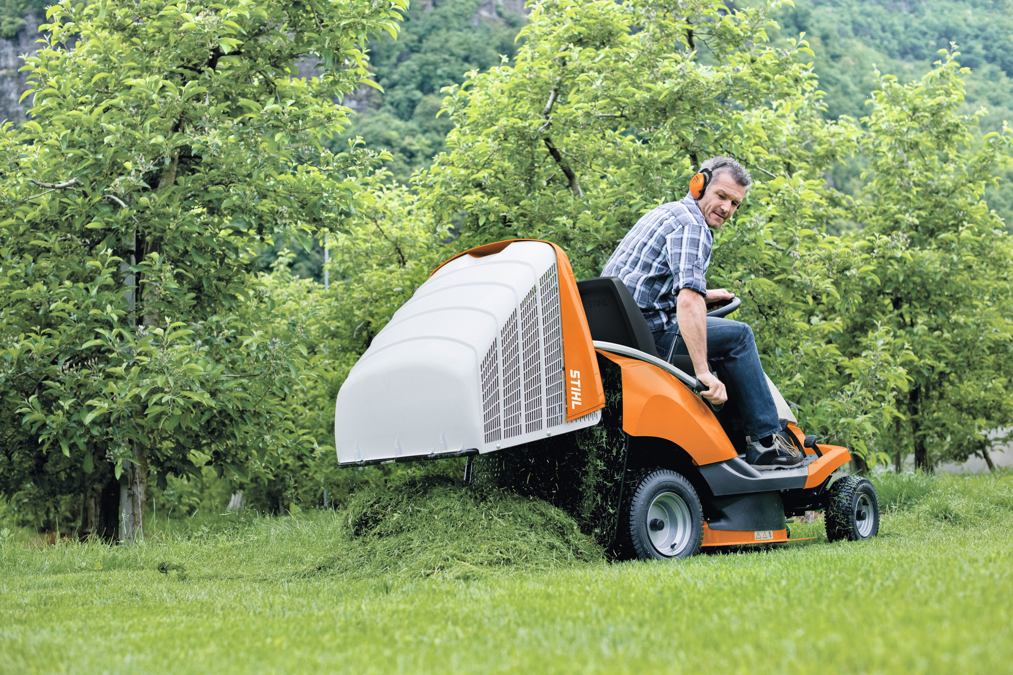 Mann benutzt STIHL RT 4082 Aufsitzmäher in grünem Garten