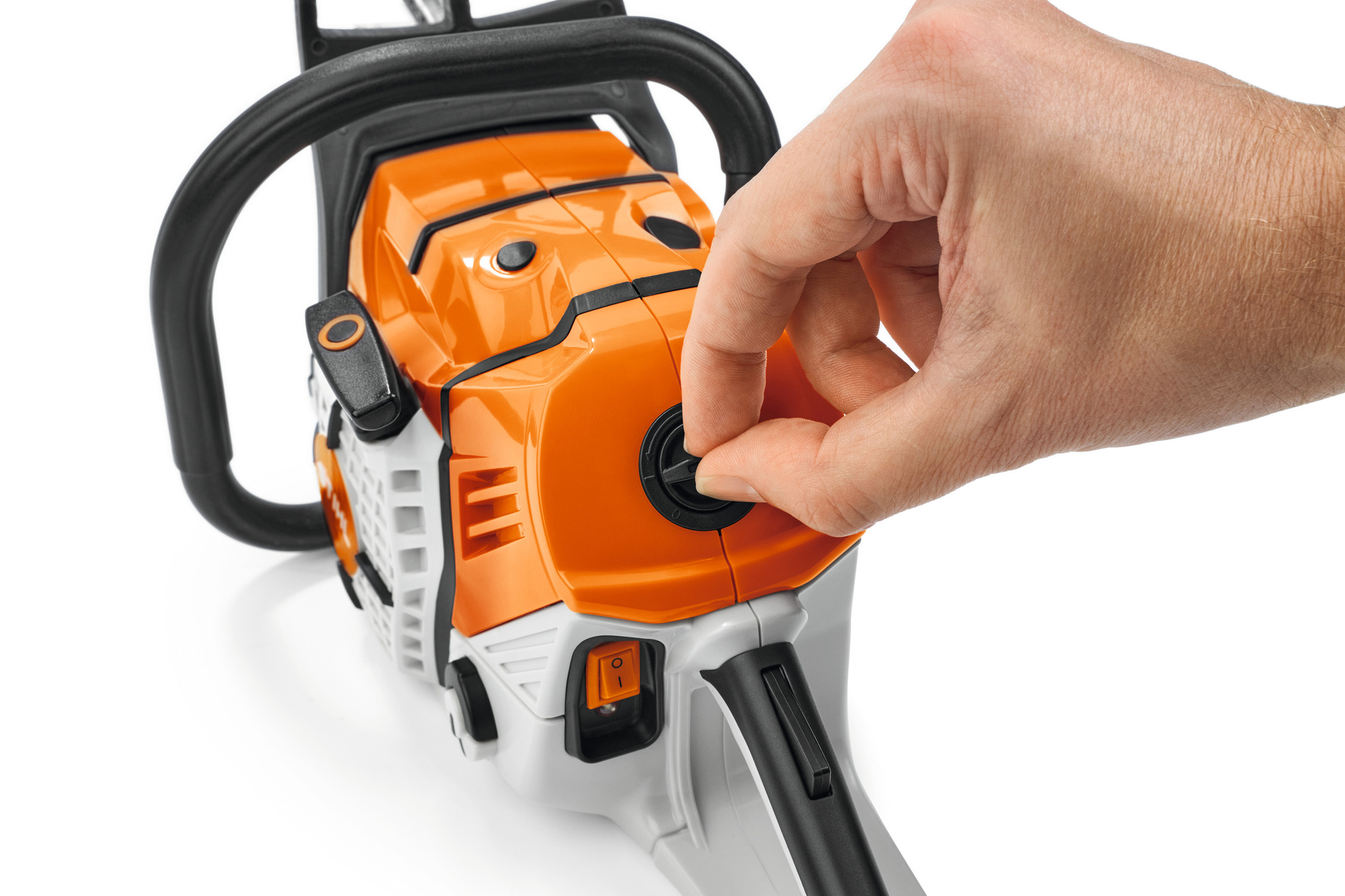 Hand betätigt Startknopf an einer Spielzeug-Kettensäge im STIHL-Design