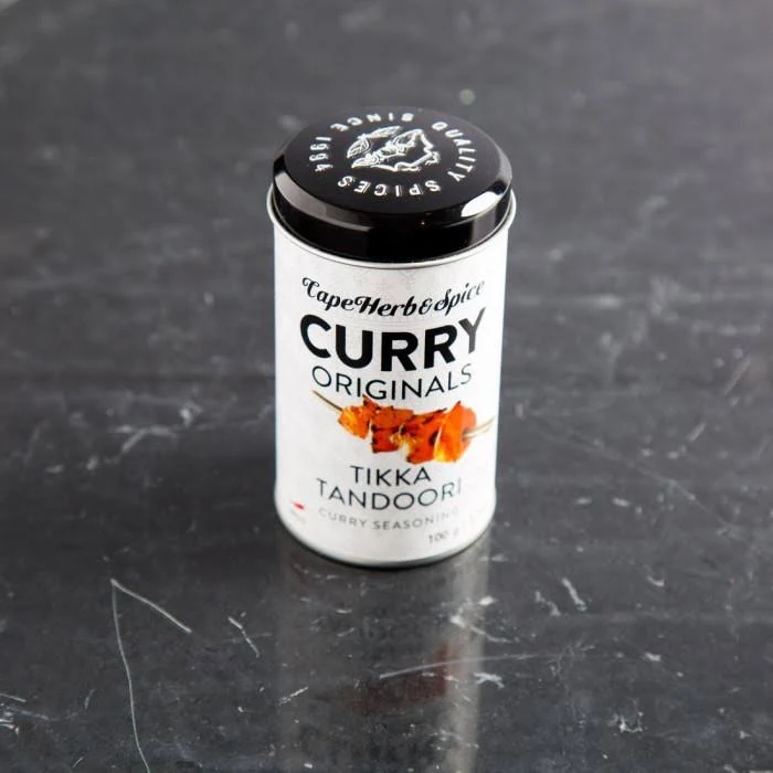 Cape Herb Rub Curry Tikka Tandoori Gewürzdose auf dunklem Marmorhintergrund