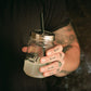Hand hält Mason Jar mit Edelstahl Strohhalm-Aufsatz von O'Donnell Moonshine
