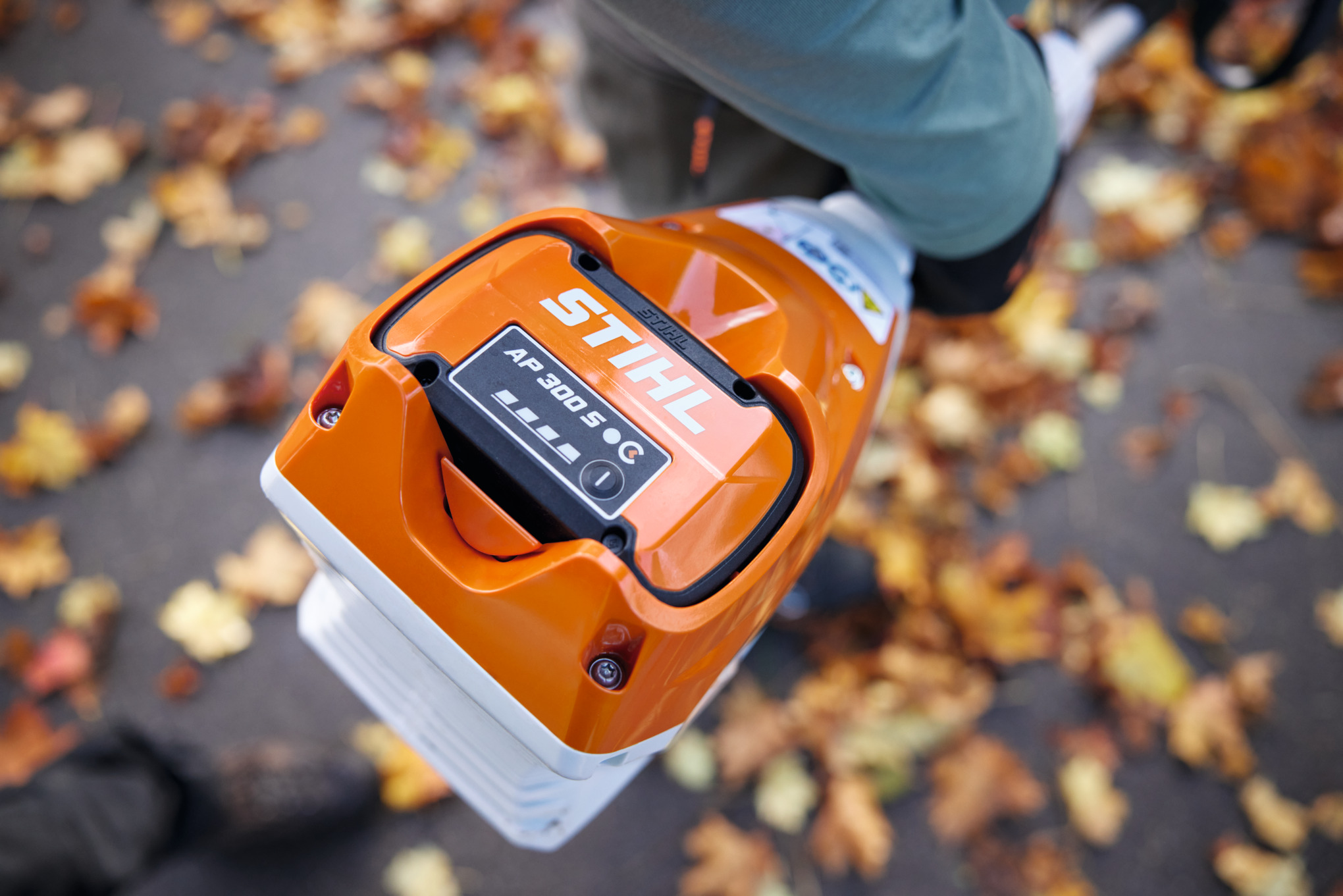 Nahaufnahme eines Stihl KMA 120 R Akku-KombiMotors mit AP 300 S Akku im Herbst