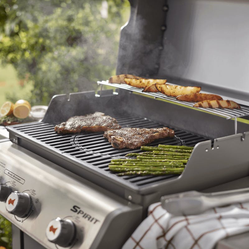 Weber Spirit 300 Gasgrill mit GBS Gussgrillrost, Steaks, Spargel und Kartoffeln im Freien