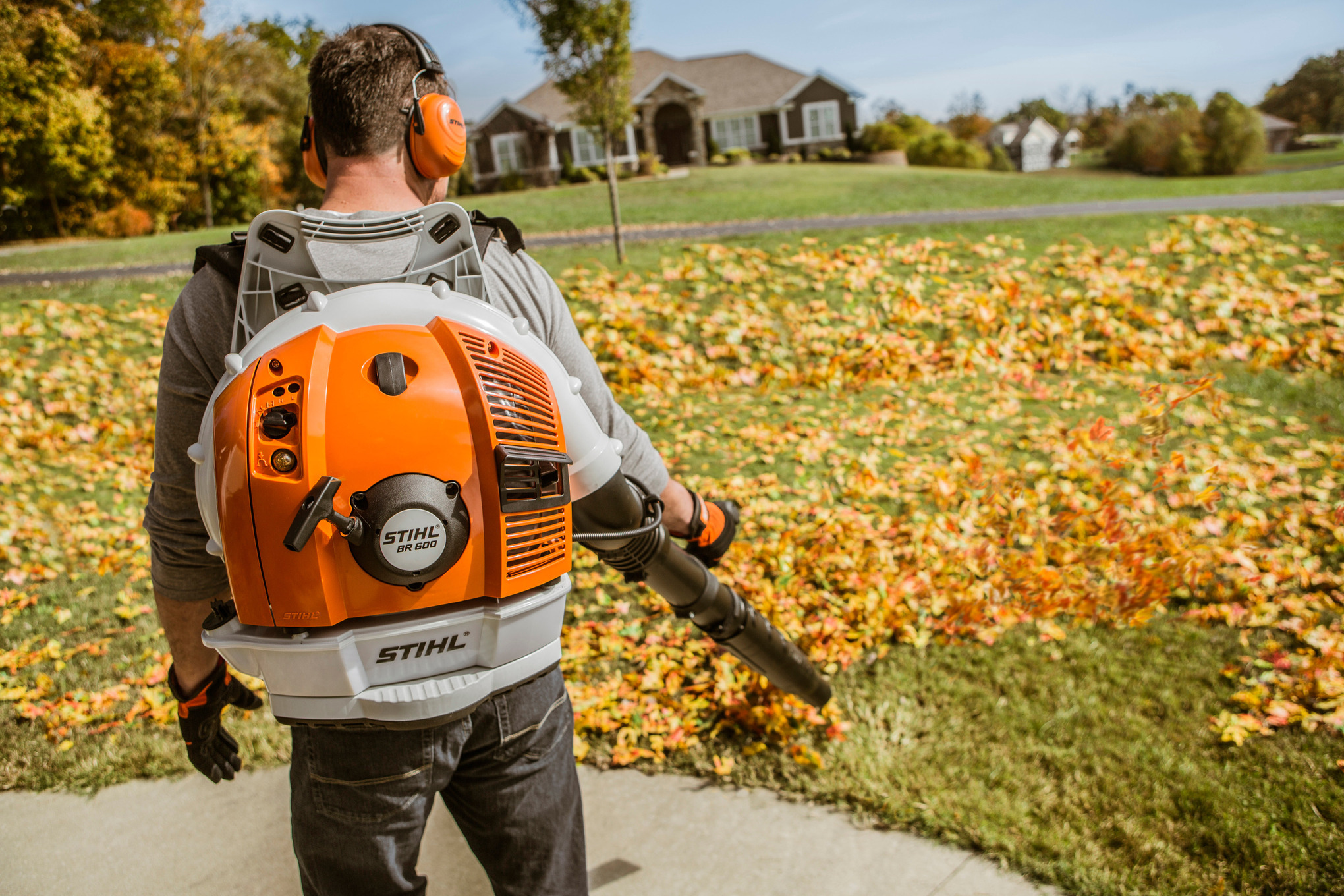 Mann verwendet STIHL BR 600 Laubbläser in herbstlichem Garten