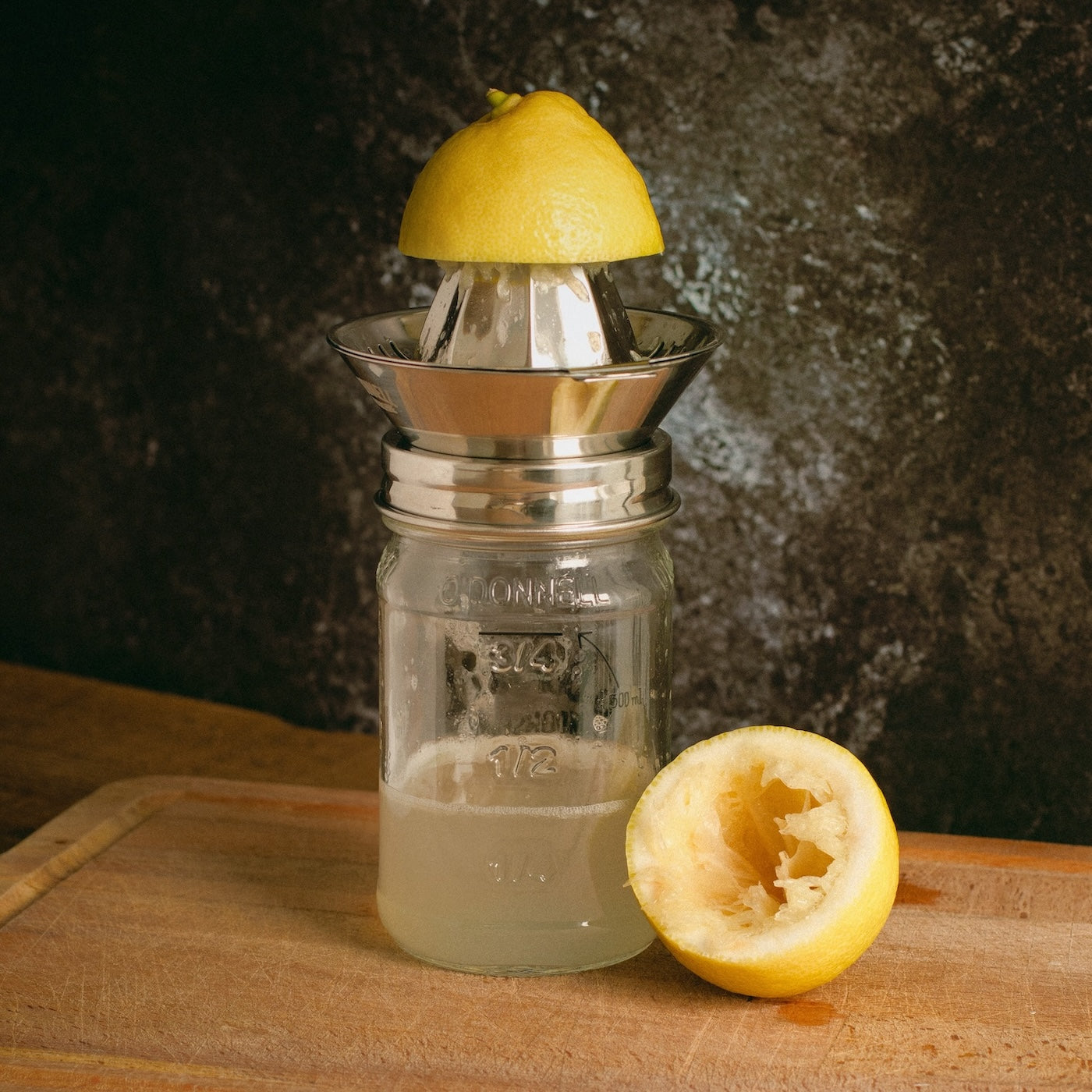 Edelstahl Zitronenpresse-Aufsatz auf Mason Jar mit frisch gepresstem Zitronensaft