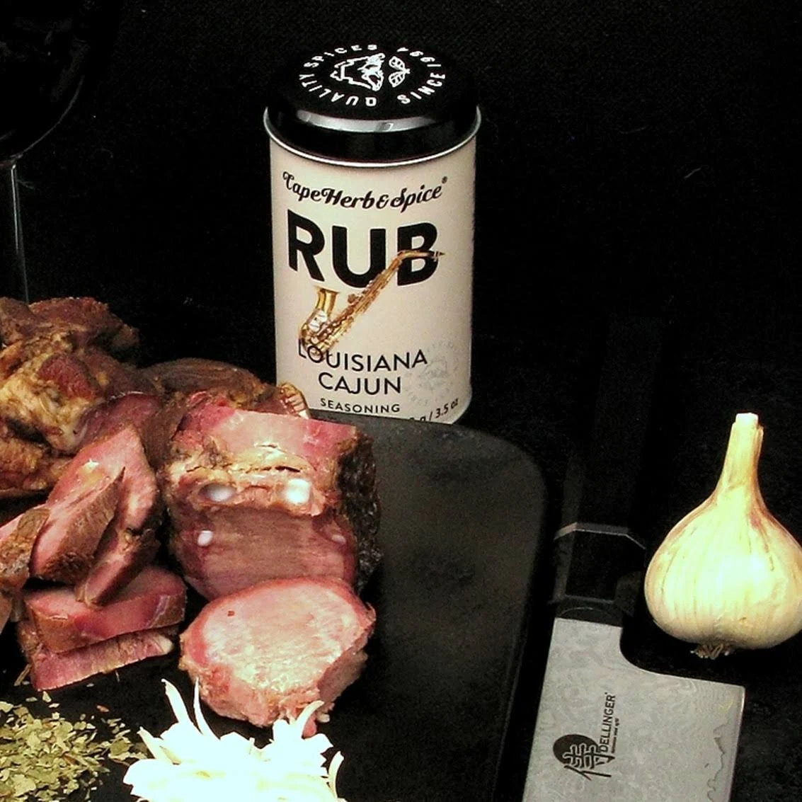 Cape Herb Rub Louisiana Cajun Gewürzdose neben gewürztem Fleisch und Knoblauch